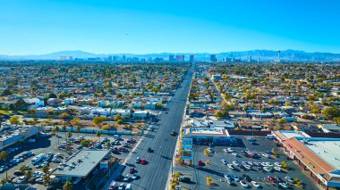 Aerial view of Las Vegas showcasing a vibrant suburban landscape leading to the iconic skyline with the Stratosphere Tower. Sunlit day reveals the blend of residential and commercial zones. clipart