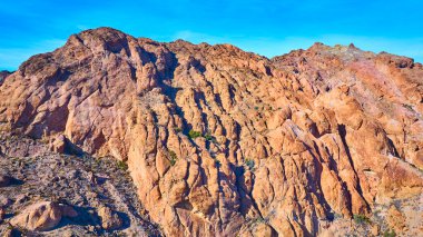 Nelson Nevadas 'ın hava manzarası canlı mavi gökyüzünün altındaki engebeli sıradağları gösteriyor. Bu dingin ve zamansız topraklardaki pürüzlü kayaların ve seyrek çöl bitkilerinin karmaşık desenlerini keşfedin..
