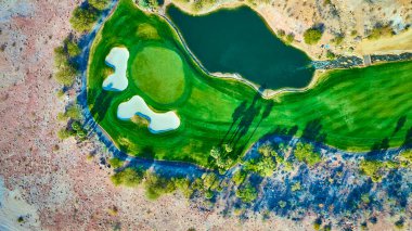 Nevada, Bootleg Canyon 'daki yemyeşil golf sahasının havadan görünüşü engebeli çöle zıt. Altın saat ışığı golf ve doğa meraklıları için sakin sahne idealini artırıyor.