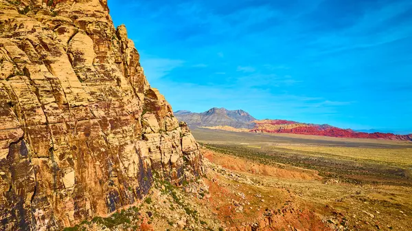 Kızıl Kaya Kanyonu, Nevada 'nın canlı renklerini ve engebeli güzelliğini yukarıdan deneyimleyin. Bu hava manzarası görkemli kumtaşı uçurumlarını ve berrak mavi gökyüzünün altındaki engin çöl manzaralarını yakalar..