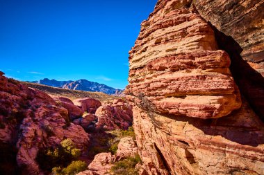 Nevada 'daki Red Rock Kanyonu' nun nefes kesici güzelliğini keşfedin. Açık mavi gökyüzünün altındaki parlak kumtaşı kayalıklarda hayret verici bir manzara. Amerika 'nın güneybatısında macera ve ilham için mükemmel bir manzara..
