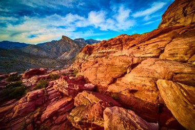 Bask in the golden hour light at Red Rock Canyon near Las Vegas. Admire the vibrant red sandstone and rugged mountains of Kraft Mountain under a brilliant blue sky. Perfect for adventure and travel clipart