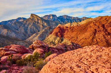 Nevada 'daki Red Rock Kanyonu' nun nefes kesici güzelliğini tecrübe edin. Bu dingin çöl manzarasında, altın saatin ılık parıltısının altındaki engebeli kumtaşı oluşumlarına ve görkemli dağlara hayret edin..