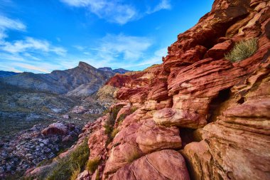 Las Vegas yakınlarındaki Kızıl Kaya Kanyonu 'nun canlı kumtaşı oluşumlarını araştırın. Kraft Dağı 'nın engebeli güzelliğini keşfedin açık mavi gökyüzü ve uzak çöl dağlarına karşı.