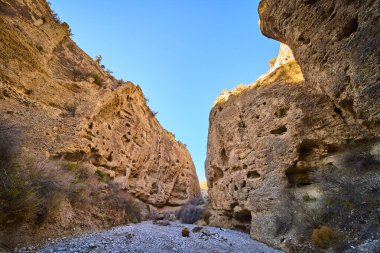 Nevada, Charleston Dağı yakınlarındaki göz kamaştırıcı yuva kanyonunu keşfedin. Yüksek kaya duvarları ve kurumuş bir nehir yatağı çöl güneşinde macera ve yalnızlık için mükemmel dramatik bir manzara yaratır..