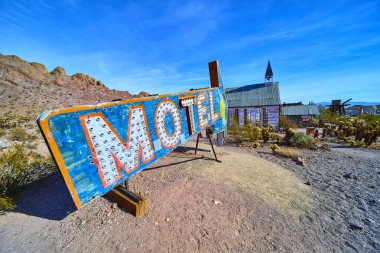 Nevada Çölü 'nde canlı mavi ve turuncu renkli pankartlarla gösterilen antika motel tabelası, parlak bir gün ortası gökyüzü altında, hayalet kasabaların kırsal kesimlerinde nostalji ve Americana' yı anımsatıyor. Yolculuk için mükemmel.