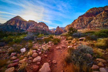 Nevada, Red Rock Kanyonu 'ndaki engebeli kaya oluşumlarının üzerinde altın saat ışıldıyor. Kayalık bir yol macera arayanları Las Vegas yakınlarındaki huzurlu çöl cennetine davet ediyor. Doğa için mükemmel.