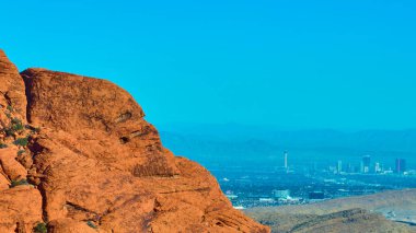 Red Rock Kanyonu 'nun nefes kesici hava manzarası Las Vegas siluetine karşı engebeli bir güzellik. Nevada 'nın çarpıcı çöl manzarasındaki doğa ve şehir yaşamının ahenkli karışımını keşfedin..