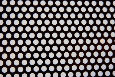 Modern endüstriyel tasarımın özünü yansıtan dairesel delikleri olan delikli metal bir levhanın yakın çekimi. Las Vegas 'ta çekilecek minimalist geometrik şablon için mükemmel.