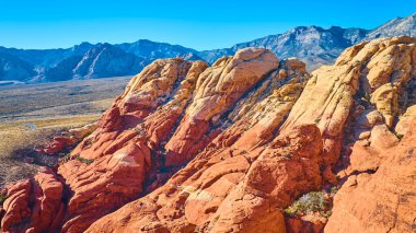 Las Vegas, Nevada yakınlarındaki Red Rock Kanyonu 'nun havadan görüntüsü. Işıl ışıl kırmızı kumtaşı oluşumları, derin mavi gökyüzü ile tezat oluşturarak, Amerika 'nın güneybatısının nefes kesici güzelliğini ve macerasını gözler önüne seriyor..