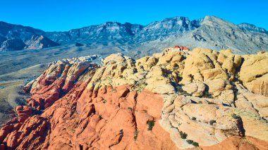 Las Vegas, Nevada yakınlarındaki Kızıl Kaya Kanyonu 'nun hava manzaralı muhteşem kumtaşı oluşumları. Canlı renkler ve engebeli dağlar macera ve doğa meraklıları için mükemmel bir manzara yaratır..