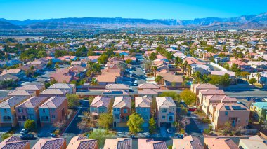 Las Vegas, Nevada 'da canlı bir banliyö mahallesinin havadan görünüşü. Güneybatı ABD 'de sürdürülebilir yaşam ve modern kentsel planlamayı kırmızı kiremitli çatılar, palmiye kaplı caddeler ve güneş panelleri ön plana çıkarıyor.