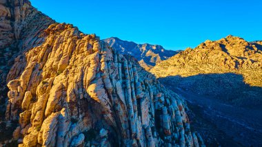 Nevada 'daki Red Rock Kanyonu' nun altın saat boyunca canlı kırmızı ve turuncu renkleri ile nefes kesici hava manzarasını deneyin. Macera, keşif ve doğa fotoğrafçılığı meraklıları için mükemmel..