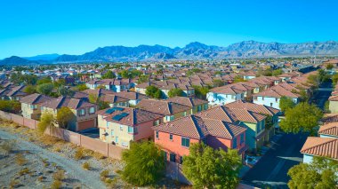 Las Vegas Nevada 'da bir banliyö mahallesinin havadan görünüşü terasotta kaplamalı çatılar ve dağ zeminine kurulmuş ağaçlarla kaplı caddeler. Gayrimenkul ve şehir planlama temaları için ideal.