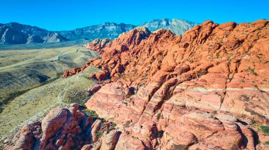 Las Vegas yakınlarındaki Red Rock Kanyonu 'nun nefes kesici güzelliğini tecrübe edin. Canlı kırmızı kumtaşı oluşumları ve geniş çöl arazilerinin havadan görünüşü macera ve keşifleri davet eder. Yolculuk için mükemmel.