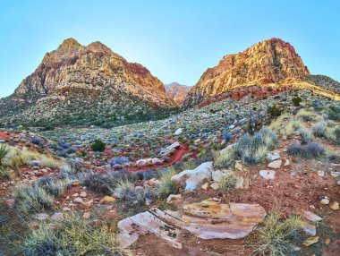 Las Vegas yakınlarındaki Kızıl Kaya Kanyonu 'nun heybetli görkemini keşfedin. Açık mavi gökyüzü altında yükselen kırmızı ve bej kayalıklar bu çarpıcı çöl manzarasında macera ve keşfi davet ediyor..