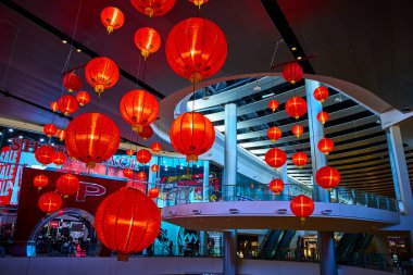 Canlı kırmızı fenerler modern bir Las Vegas alışveriş merkezini süslüyor, gösterişli mimarinin ortasında şenlikli bir atmosfer yaratıyor. Bu dinamik perakende ortamında kültür ve ticareti kutlayın.