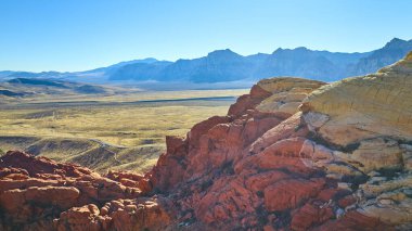 Nevada 'daki Kızıl Kaya Kanyonu' nun canlı kumtaşı oluşumlarının havadan görünüşü, Las Vegas 'ta Calico Tank Patikası' nın yakınlarında muazzam mavi gökyüzü altında çarpıcı bir manzara sanatsal özellikleri sergiliyor..