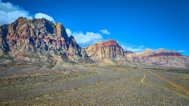 Kızıl Kaya Kanyonu engebeli kayalıklarının açık mavi gökyüzüne karşı canlı renklerini keşfedin. Las Vegas, Nevada yakınlarındaki geniş çöl arazisinde Oak Creek patikalarını keşfedin..