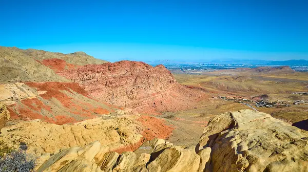 Las Vegas, Nevada yakınlarındaki Kızıl Kaya oluşumlarının nefes kesici görüntüsü. Engebeli çöl manzaralarının çarpıcı kontrastını Strip 'in şehir manzarasına karşı deneyimleyin. Seyahat için mükemmel.