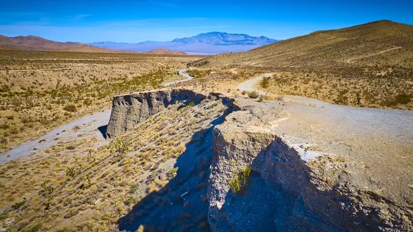 Charleston Dağı yakınlarındaki Nevada engebeli çölünün nefes kesen hava manzarası çarpıcı uçurumlar ve parlak bir gökyüzü altında sonsuz ufuklar gösteriyor. Seyahat ve macera temaları için mükemmel.