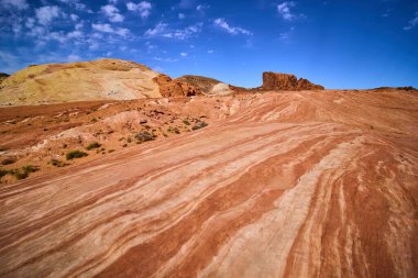 Nevada, Ateş Vadisi 'nin büyüleyici çöl manzarasını keşfedin. Parlak kırmızı kumtaşı oluşumlarına, karmaşık çizgilere ve berrak mavi gökyüzünün altında geniş açık alanlara hayret edin..