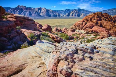 Büyük Merdiven Yolu 'ndaki canlı Kızıl Kaya Kanyonu' nu keşfedin. Çarpıcı kırmızı ve pembe oluşumların geniş düzlükler ve Nevada 'da açık mavi gökyüzünün altındaki yüksek dağlarla tezat oluşturduğu yer..