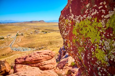 Las Vegas yakınlarındaki Grand Staircase Patikası 'nda canlı bir çöl manzarası. Çarpıcı kırmızı kaya, yeşil liken ve uçsuz bucaksız ufuklar açık mavi gökyüzü altında keşif ve maceraya davetiye çıkarır. Seyahat için ideal