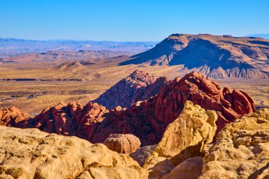 Nevada Red Rock Kanyonu 'nda açık mavi gökyüzünün altında canlı kırmızı kumtaşı oluşumları. Las Vegas yakınlarındaki Calico Tank Yolu 'ndaki çöl manzarasının engin güzelliğini görün. Macera için mükemmel.