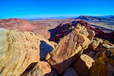 Las Vegas 'taki Calico Tank Yolu' nun nefes kesici güzelliğini keşfedin. Açık mavi gökyüzü altında sıcak kumtaşı ve kırmızı kaya oluşumlarına hayret, macera ve keşif için mükemmel..