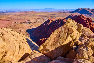 Las Vegas yakınlarındaki engebeli kumtaşı oluşumları ve canlı renkleriyle Red Rock Kanyonu 'nun göz kamaştırıcı manzarası. Deneyim doğası gereği Calico Tank Yolu 'nda güzellik görülür. Şehir ufuk çizgisi uzaktadır..