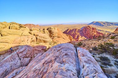 Yalnız bir yürüyüşçü, Red Rock Kanyonu 'nun altın saatindeki hareketli kumtaşı oluşumlarını keşfeder. Las Vegas, Nevada yakınlarındaki Calico Tank Yolu 'nun muazzam güzelliğini ve macerasını tecrübe edin..