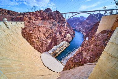 Boulder City 'den Hoover Barajı ve Colorado Nehri' nin muhteşem manzarası. Zarif köprüsü ve berrak gökyüzünün altındaki engebeli uçurumları olan ikon mühendisliği. Yenilik ve sürdürülebilirlik temaları için mükemmel.