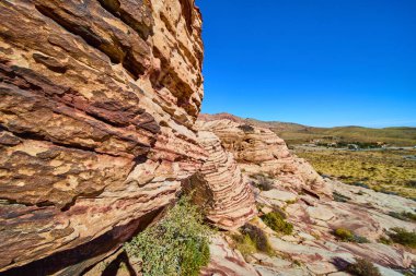 Nevada, ABD 'deki Grand Staircase Trail' de açık mavi gökyüzü altında parlak kumtaşı oluşumlarının nefes kesici görüntüsü. Yükselen kayalar ve çöl, gösteriş meraklısı doğal güzellikler ve maceralar.