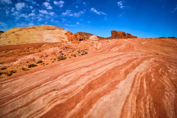 Nevada, Ateş Vadisi 'nin büyüleyici çöl manzarasını keşfedin. Parlak kırmızı kumtaşı oluşumlarına, karmaşık çizgilere ve berrak mavi gökyüzünün altında geniş açık alanlara hayret edin..