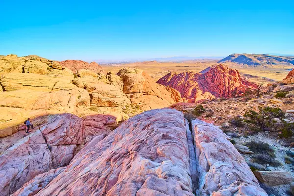 Yalnız bir yürüyüşçü, Red Rock Kanyonu 'nun altın saatindeki hareketli kumtaşı oluşumlarını keşfeder. Las Vegas, Nevada yakınlarındaki Calico Tank Yolu 'nun muazzam güzelliğini ve macerasını tecrübe edin..