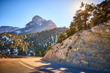 Nevada 'daki Charleston Dağı' nda altın saat parlıyor. Dolambaçlı bir yol, keşfi hiç bitmeyen yeşil ağaçların ve karla kaplı tepelerin arasına davet eder. Seyahat reklamları için mükemmel doğa, dingin güzellik ve macera..
