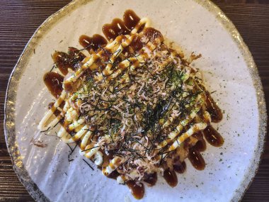 Bu nefis okonomiyaki ile otantik Japon mutfağının tadını çıkarın, canlı renklerini ve dokularını vurgulamak için güzelce kaplanmış, yemek tutkunları ve mutfak malzemeleri için mükemmel..