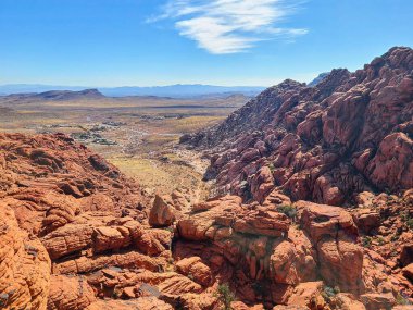 Nevada 'daki Red Rock Kanyonu' nun nefes kesici manzarası. Canlı kırmızı kumtaşı oluşumları ve dolambaçlı bir yol açık mavi gökyüzünün altında maceraya davetiye çıkarıyor. Seyahat ve keşif temaları için mükemmel.