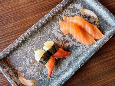 Las Vegas 'ta lüks bir restoranda seramik tabakta zarif bir suşi düzeneği. Canlı somon balığı ve midye nigiri sergileniyor. Japon mutfağı sanatının ve lüks yemek sanatının tadına bakıyorlar..