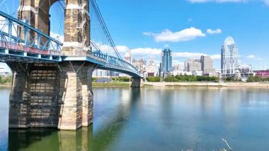 Hava Yayası Çekimi: Cincinnatis 'in çarpıcı ufuk çizgisini ve ikonik Roebling Köprüsünü tecrübe edin. Ohio Nehri, tarihi modern şehir cazibesiyle harmanlayan canlı şehir manzarasını yansıtıyor..