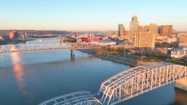 Havadan Uç: Cincinnatis 'in altın saatinde canlı bir şehir manzarası yaşayın, Ohio Nehri boyunca ikonik ufuk çizgisini, karmaşık köprüleri ve manzaralı nehir manzarasını sergileyin.