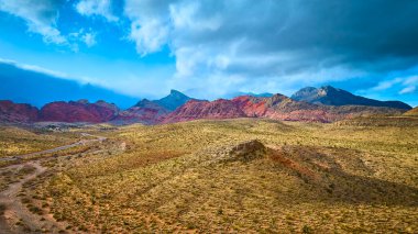 Las Vegas yakınlarındaki Red Rock Kanyonu 'nun hava manzarası dinamik bulutlar altında canlı uçurumlar sergiliyor. Doğayı keşfedin engebeli zirveler ve çöl arazisi macerayı ve keşfi davet ediyor..