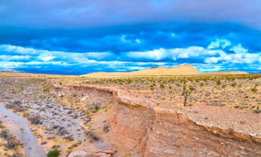 Las Vegas yakınlarındaki Red Rock Kanyonu 'nda yakalanan bu panoramik hava manzarası dramatik fırtına bulutları altında engebeli bir çöl manzarasını sergiliyor..