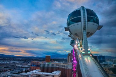 Las Vegas 'ın canlı ruhunu, parlak bir gökyüzüne karşı aydınlatılmış, bu çarpıcı yüksek silindirli gözlem tekerleğiyle yaşayın. Seyahat ve turizm projeleri için mükemmel..