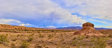 Boulder Citys 'in çöl manzarasının nefes kesici güzelliğini tecrübe edin. Altın bir öğleden sonra güneşi altında yükselen kaya oluşumlarına ve dirençli bitki örtüsüne hayret. Macera ya da çevre için mükemmel