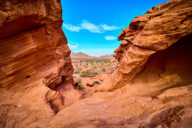 Nevada, Boulder City 'deki Redstone Dune' un nefes kesici kızıl kaya oluşumlarını araştırın. Parlak mavi bir gökyüzü altında engebeli jeoloji tarafından çerçevelenmiş çöl manzarasının ebedi güzelliğini deneyimleyin..