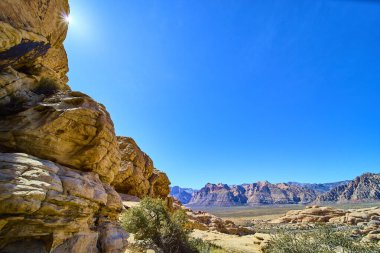Kızıl Kaya Kanyonları 'nın engebeli güzelliğinin tadını çıkarın parlak mavi gökyüzünün altında güneş ışığı oluşumları. Las Vegas 'ın engin çöl manzarasında huzuru keşfeden Nevadas Turtlehead Jr..