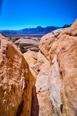 Nevada 'daki Red Rock Kanyonu' nun saf güzelliğini keşfedin. Güneş ışığıyla yıkanan yüksek kumtaşı oluşumları uzak dağlar ve uçsuz bucaksız mavi gökyüzüne karşı macera ve yalnızlığı çağrıştırıyor..