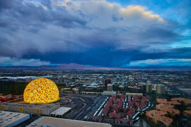 Alacakaranlıkta Las Vegas 'ın gökyüzü manzarası canlı bir gökyüzü ve The Sphere' de ışıklandırılmış mojiyle süslenmiş kubbe. Dramatik bulutlu gökyüzü Nevada 'daki bu modern şehir manzarasını güçlendiriyor.